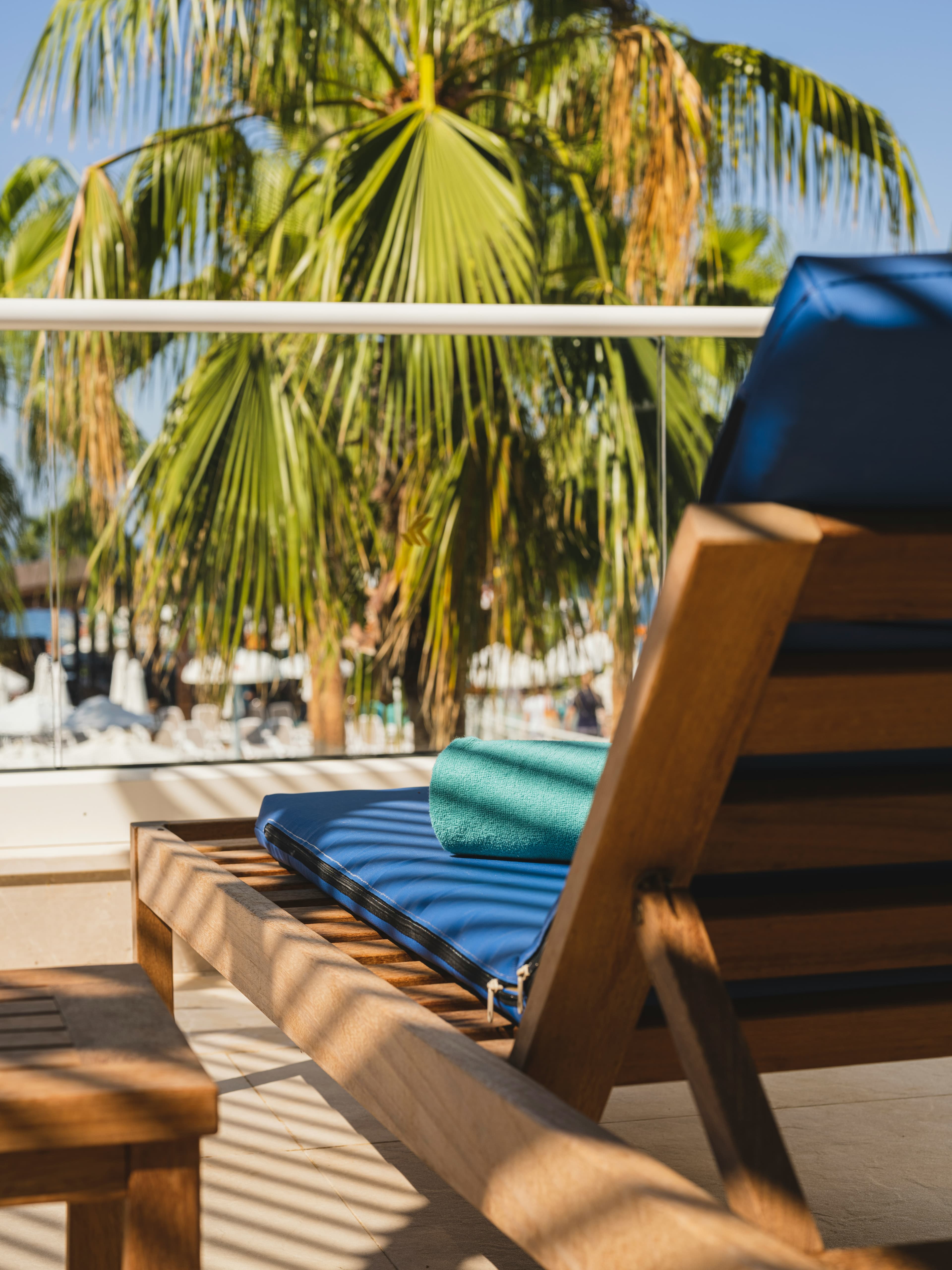 A sun lounger beneath palm trees at a luxury resort